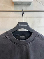 Balenciaga dark gray T-shirt with crew neck and distressed seams, hanging on BALENCIAGA tag