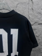 Balenciaga T-shirt back close-up with white “01” number print on dark navy fabric
