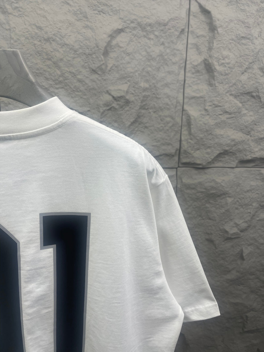 White Balenciaga T-shirt sleeve and side view with navy “01” graphic