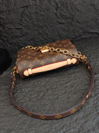 Brown monogram crossbody bag with long strap and decorative light-colored strap trim