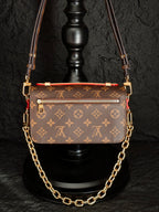 Brown monogram crossbody bag with top flap, decorative trim, and gold-tone chain strap