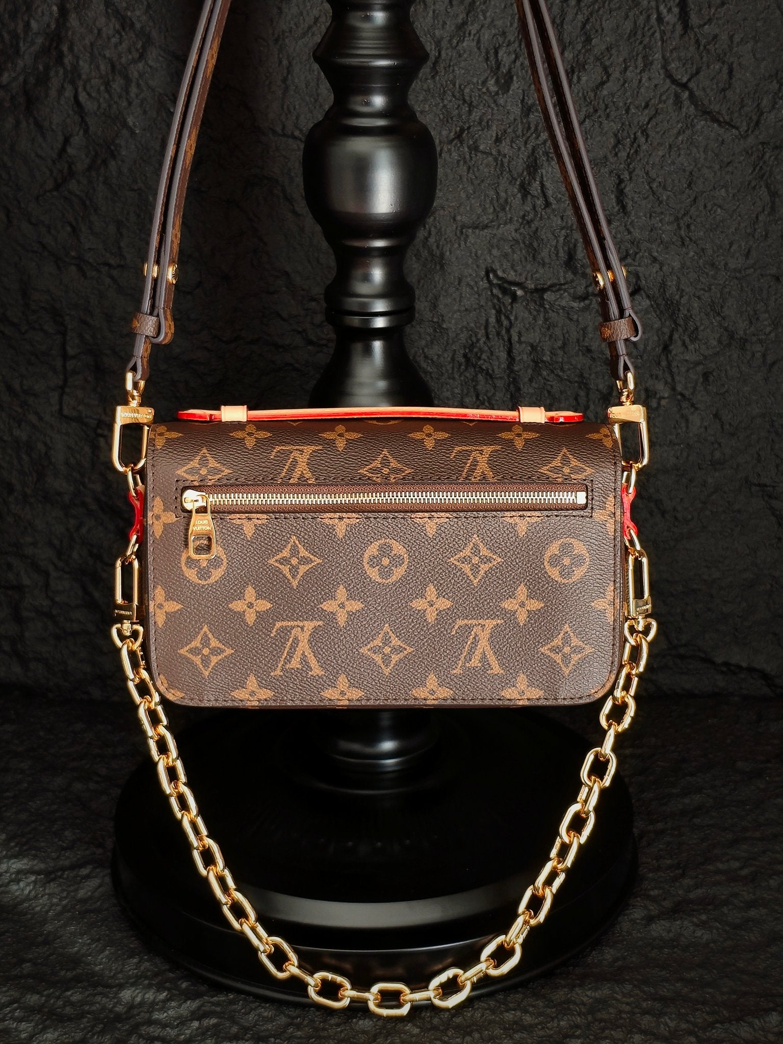 Brown monogram crossbody bag with top flap, decorative trim, and gold-tone chain strap