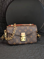 Brown monogram crossbody bag with front flap and gold-tone clasp detail