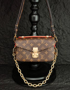 Brown monogram crossbody bag with front flap and gold-tone chain strap