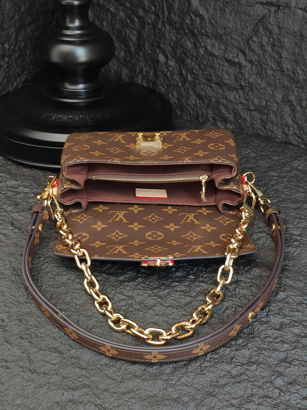 Brown monogram crossbody bag with front flap, gold-tone clasp, and chain strap