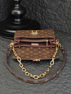 Brown monogram crossbody bag with front flap, gold-tone clasp, and chain strap