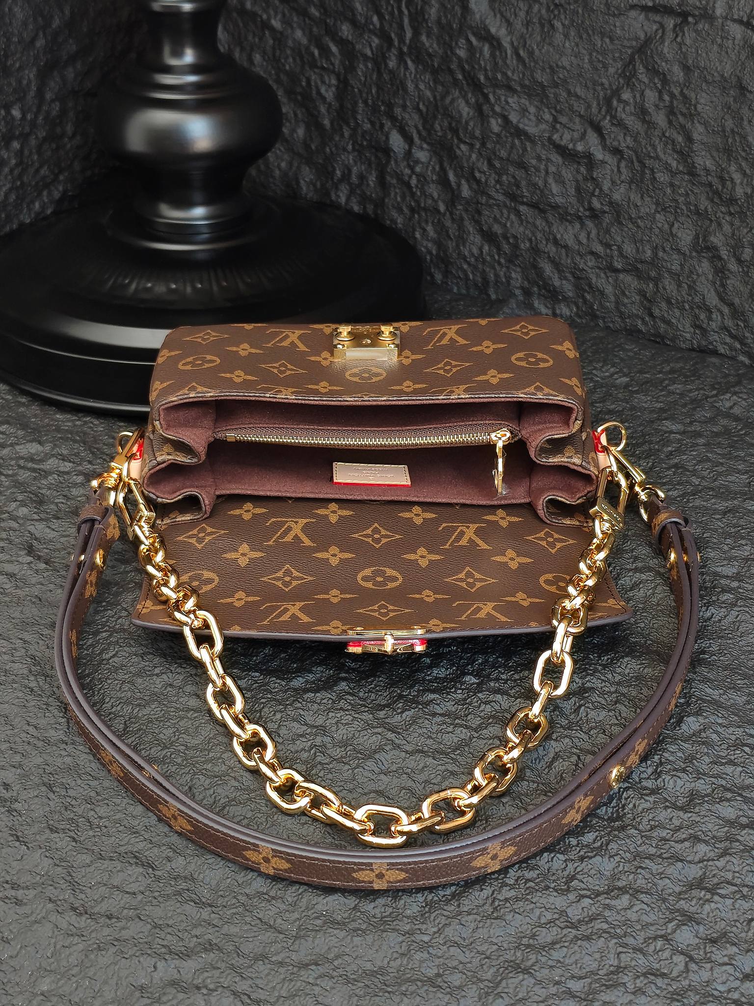 Brown monogram crossbody bag with front flap, gold-tone clasp, and chain strap