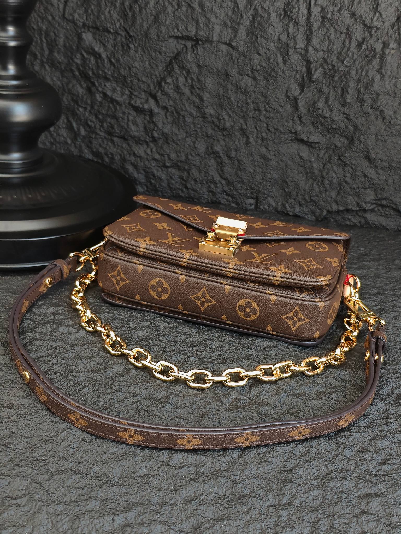 Brown monogram crossbody bag with flap closure and gold-tone chain strap