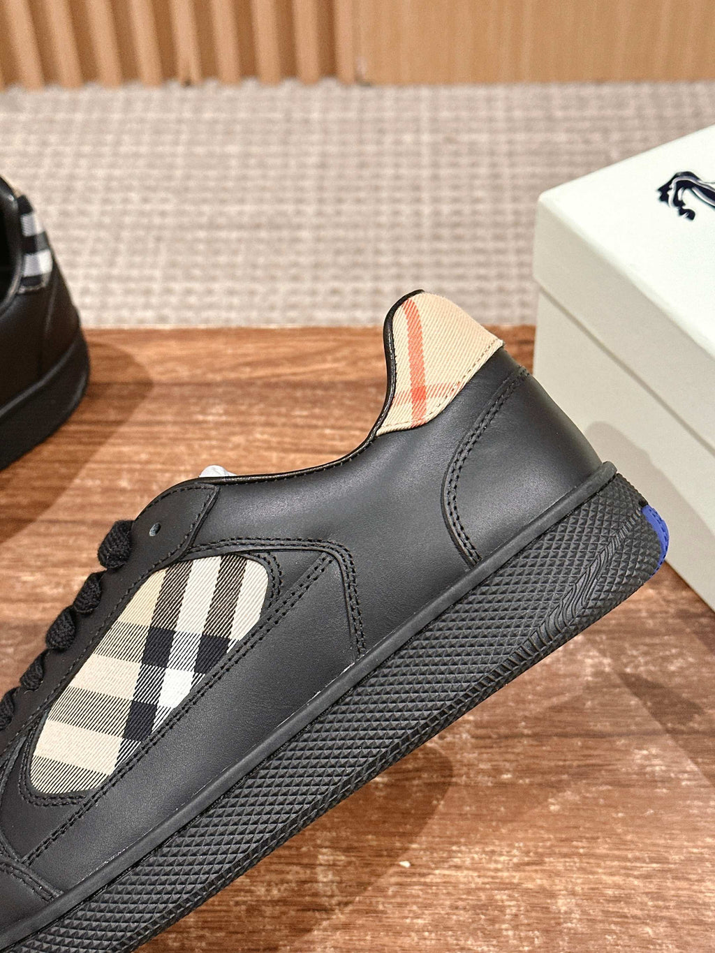 Burberry black leather sneaker with check panel near toe and textured sole