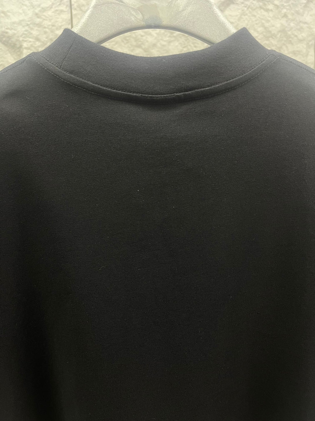 Black crewneck T-shirt collar detail with soft fabric texture