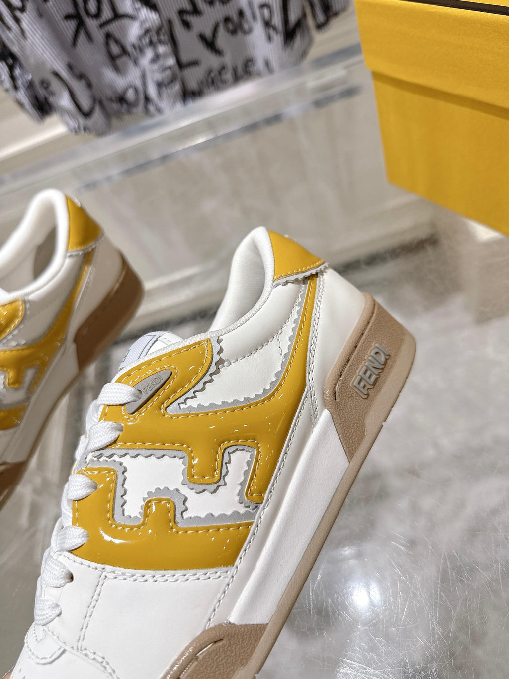 Fendi white leather sneakers with yellow logo overlay and tan sole