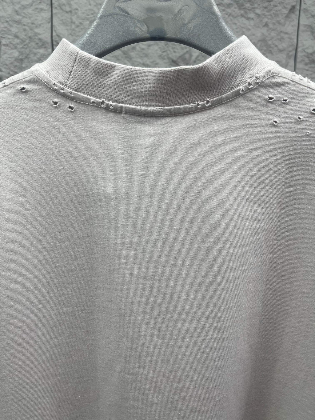 White Balenciaga T-shirt neckline detail with small studs along collar