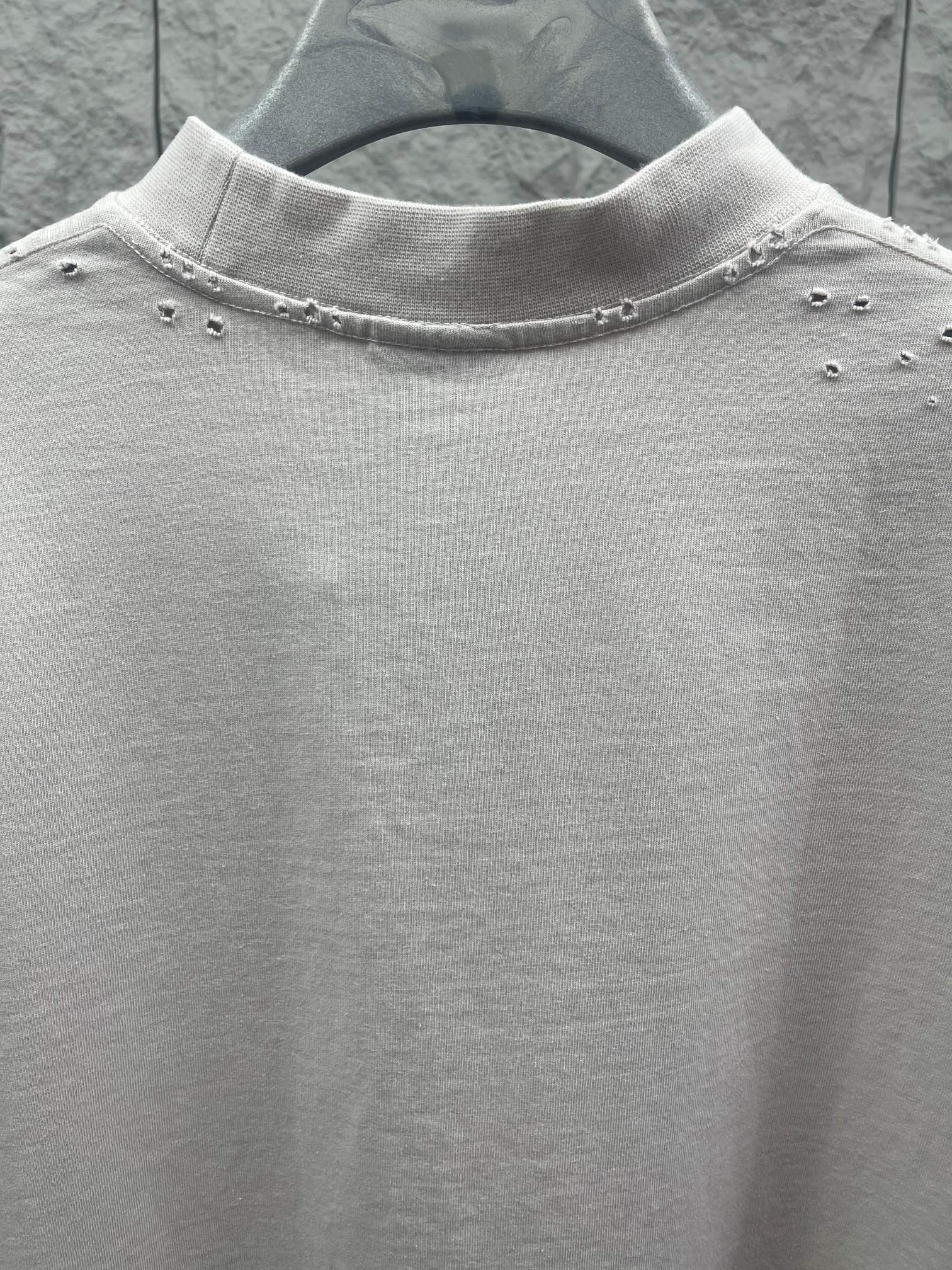 White Balenciaga T-shirt neckline detail with small studs along collar