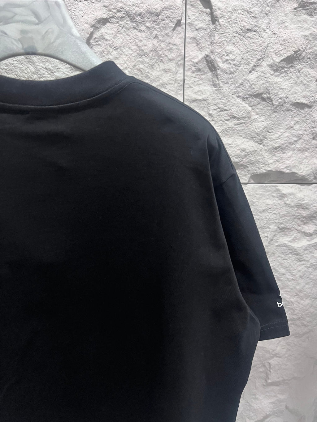 Black short-sleeve T-shirt with partial Balenciaga logo on sleeve