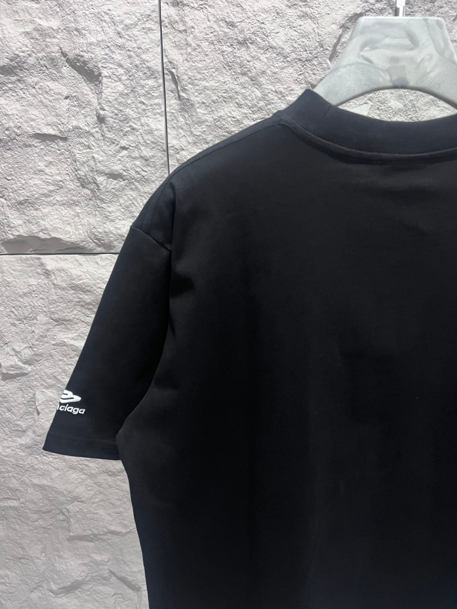 Black short-sleeve T-shirt with sleeve logo, angled view