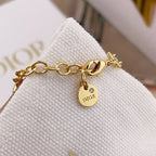 Gold chain bracelet with pearl beads and DIOR logo charm on a clasp