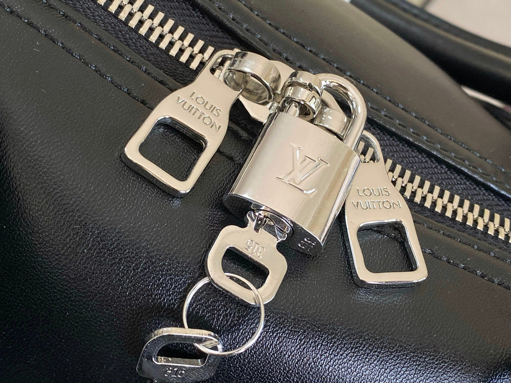 Louis Vuitton men's duffel bag close-up of zipper pulls with LV charms and logo labels