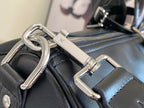 Louis Vuitton men's duffel bag close-up of metal hardware and strap loops on dark leather