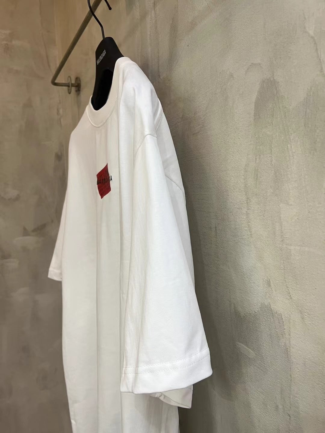 Balenciaga white T-shirt side view with red logo patch at chest