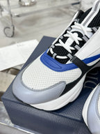 Low-top sneaker close-up: white mesh, black trim, blue accent stripe, lace-up front