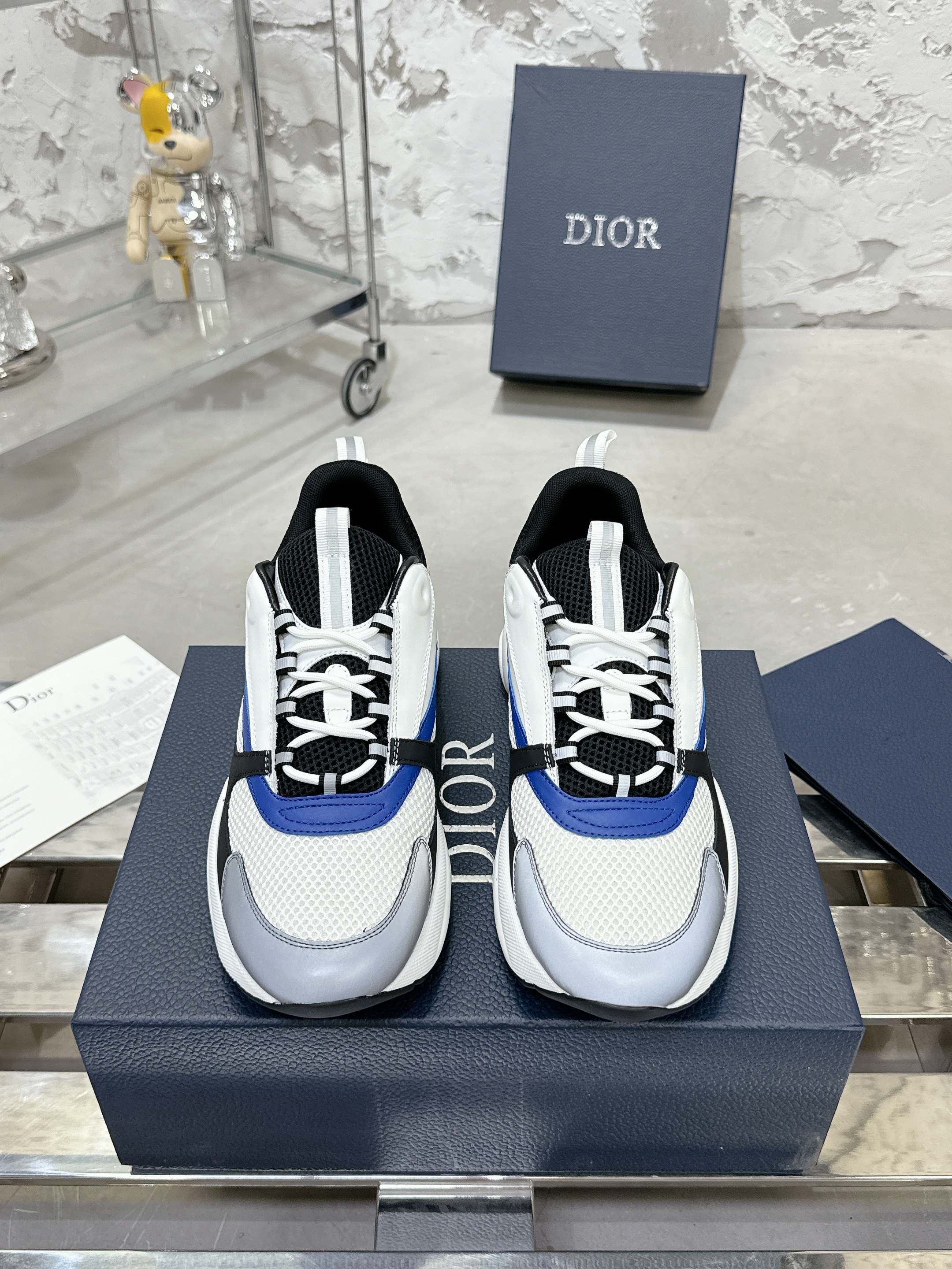 Low-top sneakers in white with black and blue accents, lace-up with textured sole