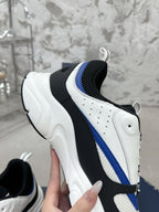 Sneaker profile view with white leather panels, black heel, and blue stripe detail
