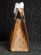 Tan monogram drawstring-style handbag with ribbon handles and gold-tone grommets