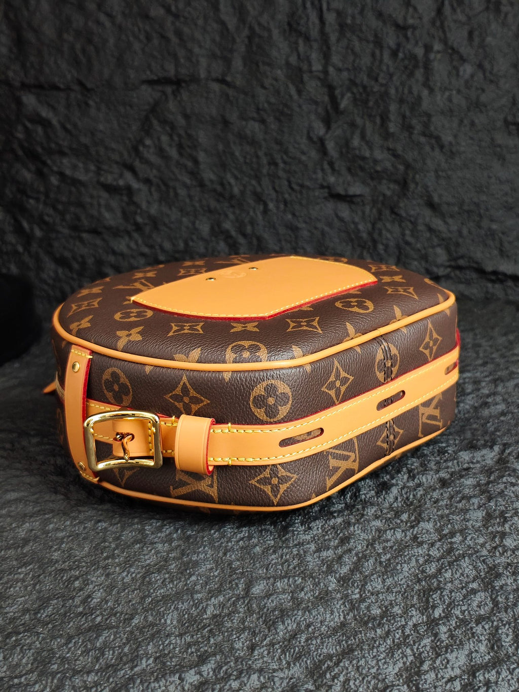 Monogram canvas bag with tan leather top, gold buckle, and tan shoulder strap