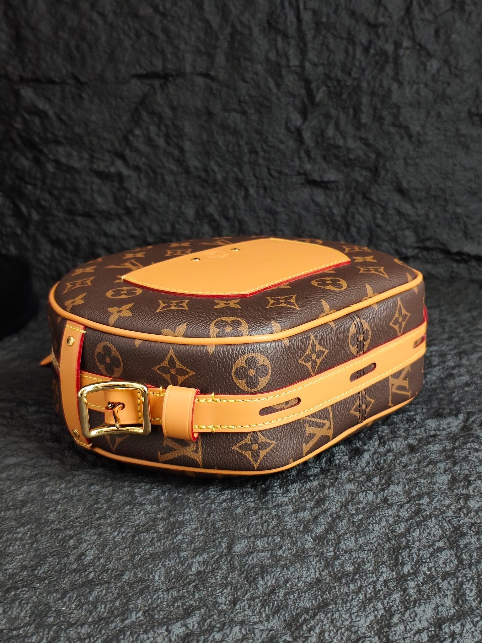 Monogram canvas bag with tan leather top, gold buckle, and tan shoulder strap