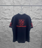 Balenciaga dark T-shirt with centered red shield crest and Balenciaga wordmark on front