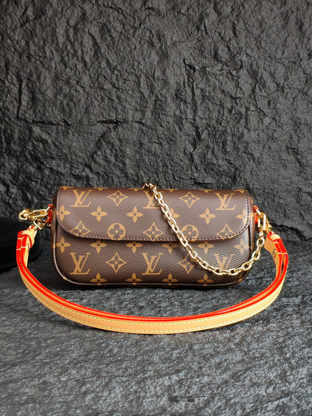Louis Vuitton monogram crossbody bag with flap, gold chain, and orange-red strap