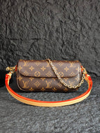 Louis Vuitton monogram crossbody bag with flap, gold chain, and orange-red strap
