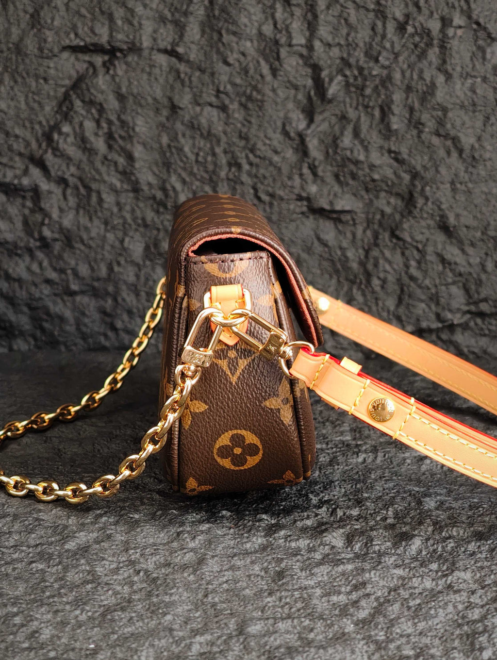 Louis Vuitton monogram bag with gold chain, tan leather strap, and clasp detail