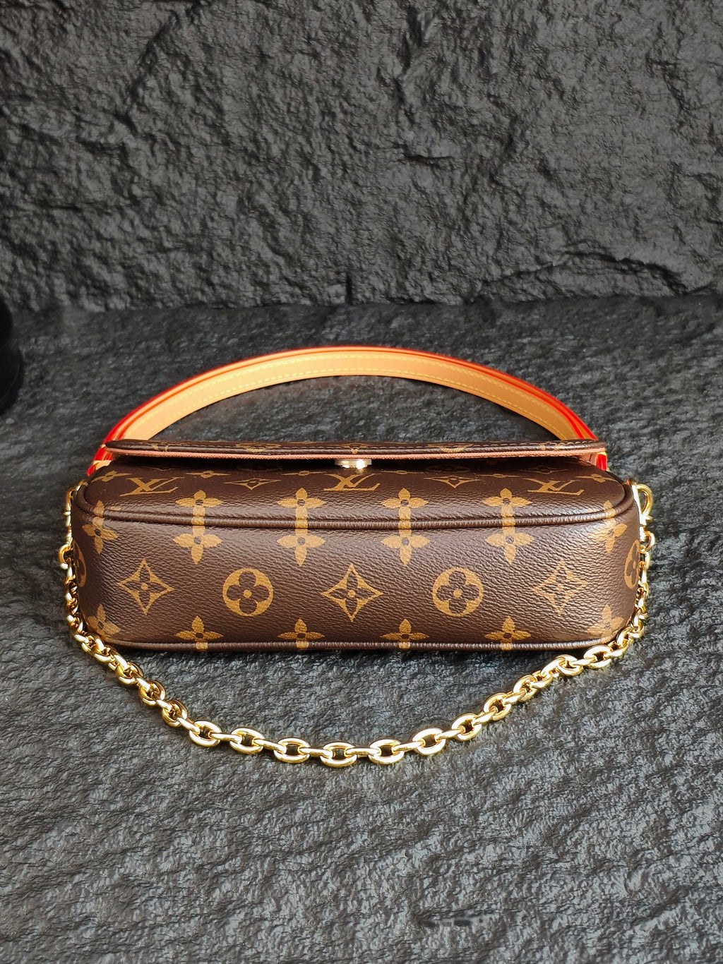 Louis Vuitton monogram bag with orange-red piping and gold chain strap
