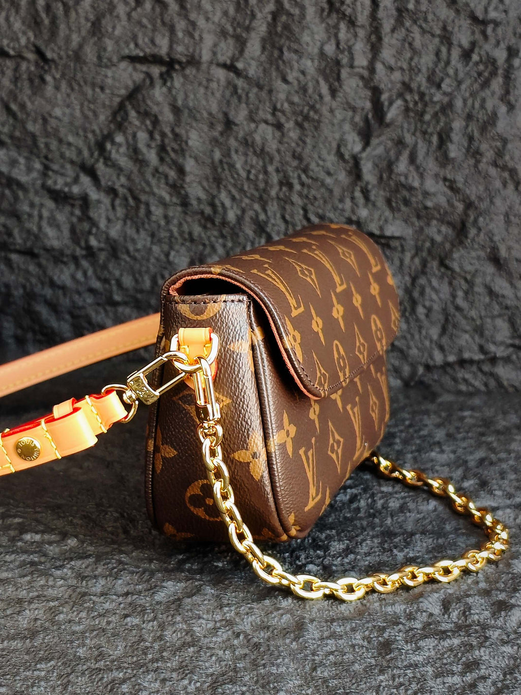 Louis Vuitton monogram mini bag with gold chain and tan strap, side view