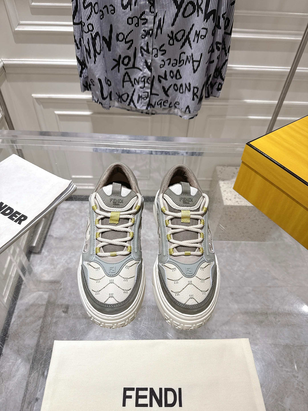 Gray and white unisex Fendi sneakers with lace-up front and yellow accents