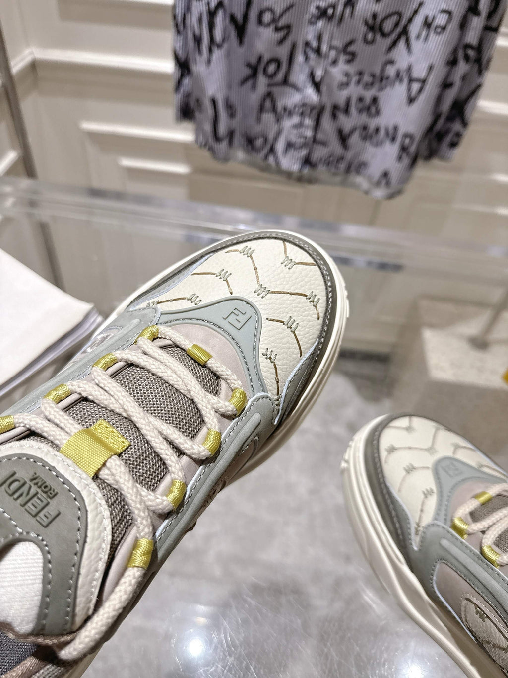 Close-up of gray Fendi sneaker toe with laces and textured logo patch