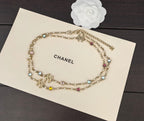 Gold-tone Chanel charm necklace with multicolor stones, layered chain, and hanging charms