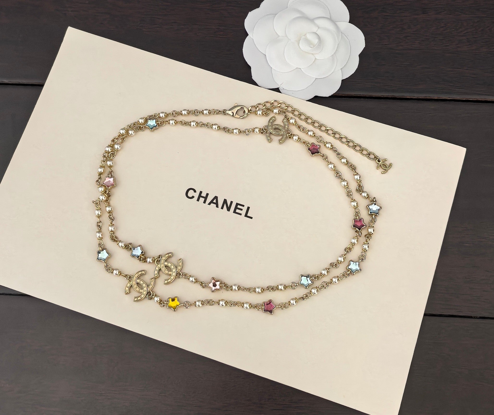 Gold-tone Chanel charm necklace with multicolor stones, layered chain, and hanging charms