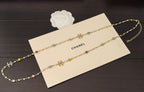 Gold-tone Chanel necklace with two thin chains and multicolor gemstone charms