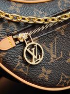 Louis Vuitton monogram bag close-up: gold chain, zipper pull and LV emblem