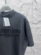 Dark T-shirt shoulder and chest close-up with embossed Balenciaga logo