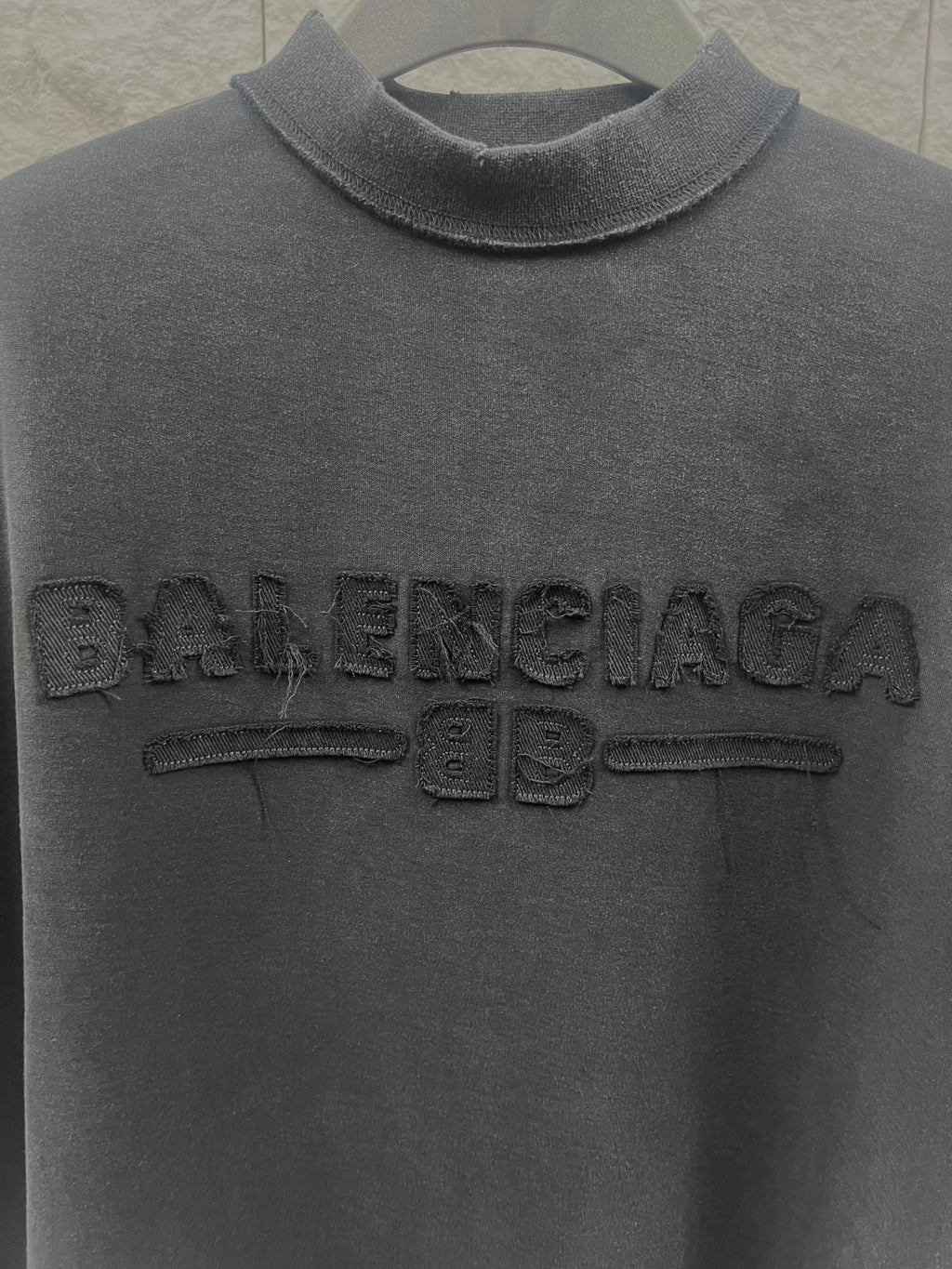 Dark T-shirt collar and large embossed Balenciaga logo on the chest