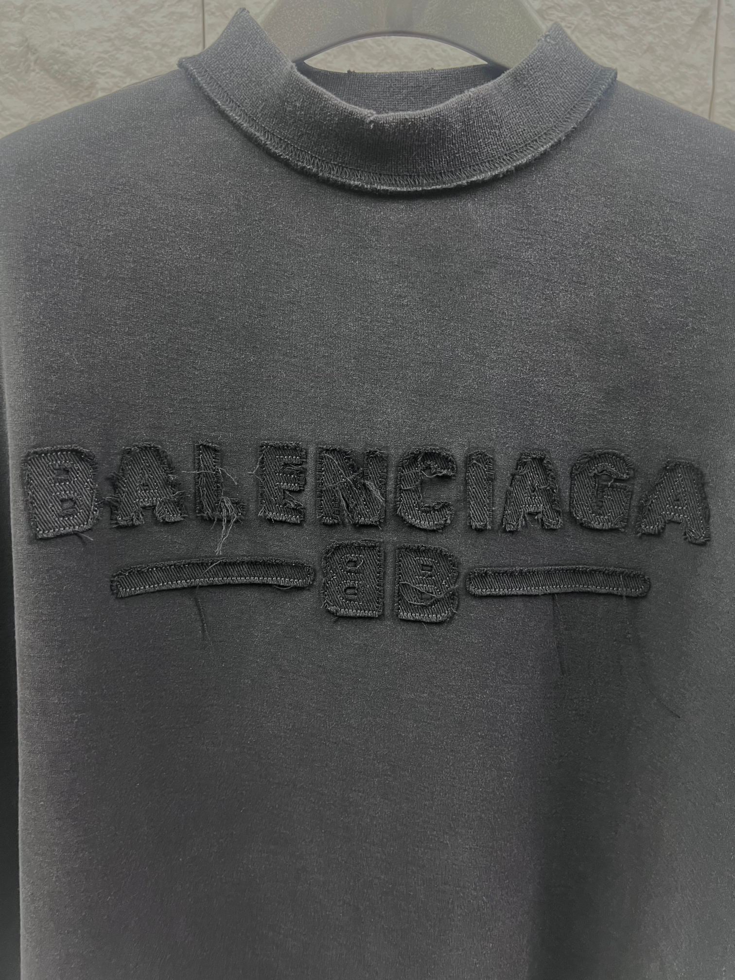 Dark T-shirt collar and large embossed Balenciaga logo on the chest