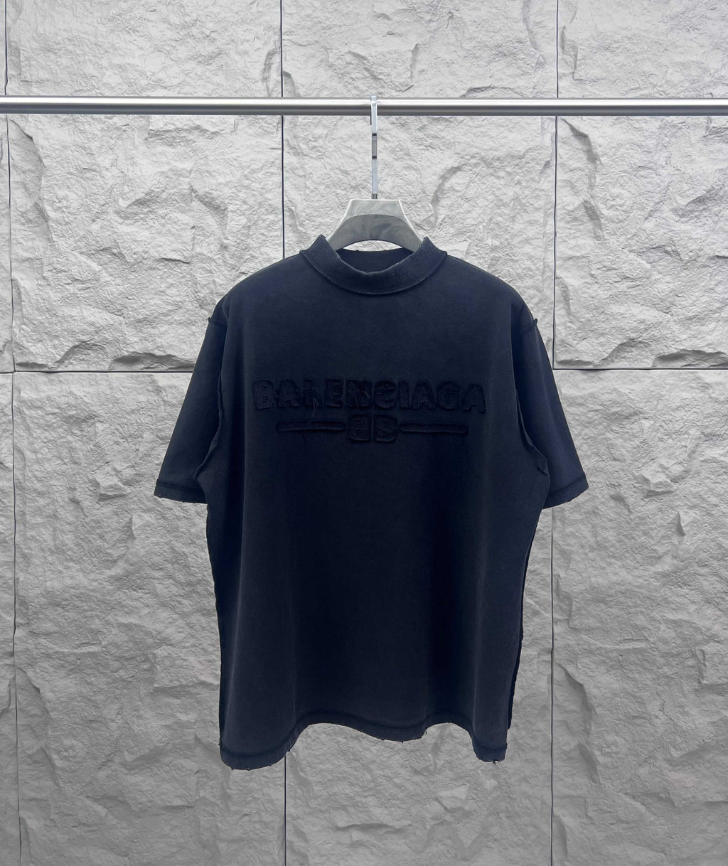 Dark crew-neck T-shirt with embossed Balenciaga logo on the chest