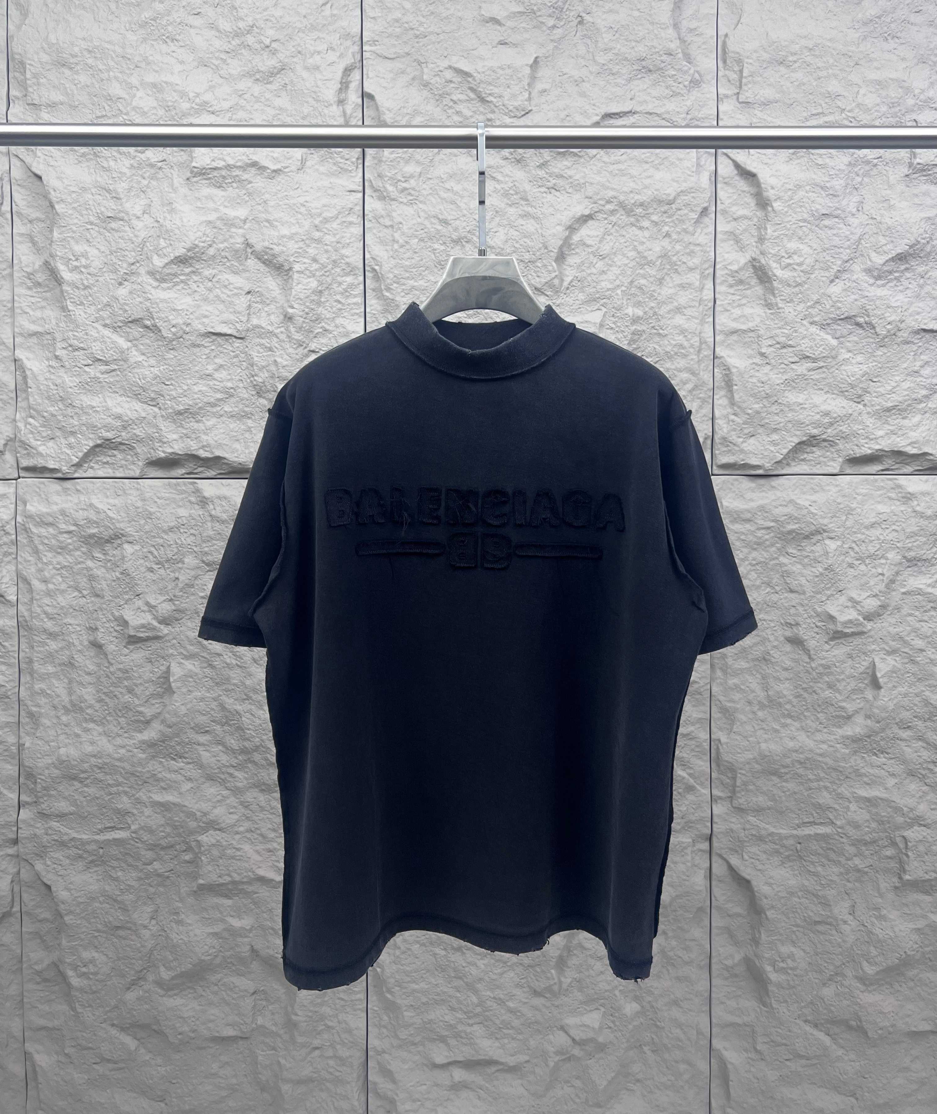 Dark crew-neck T-shirt with embossed Balenciaga logo on the chest