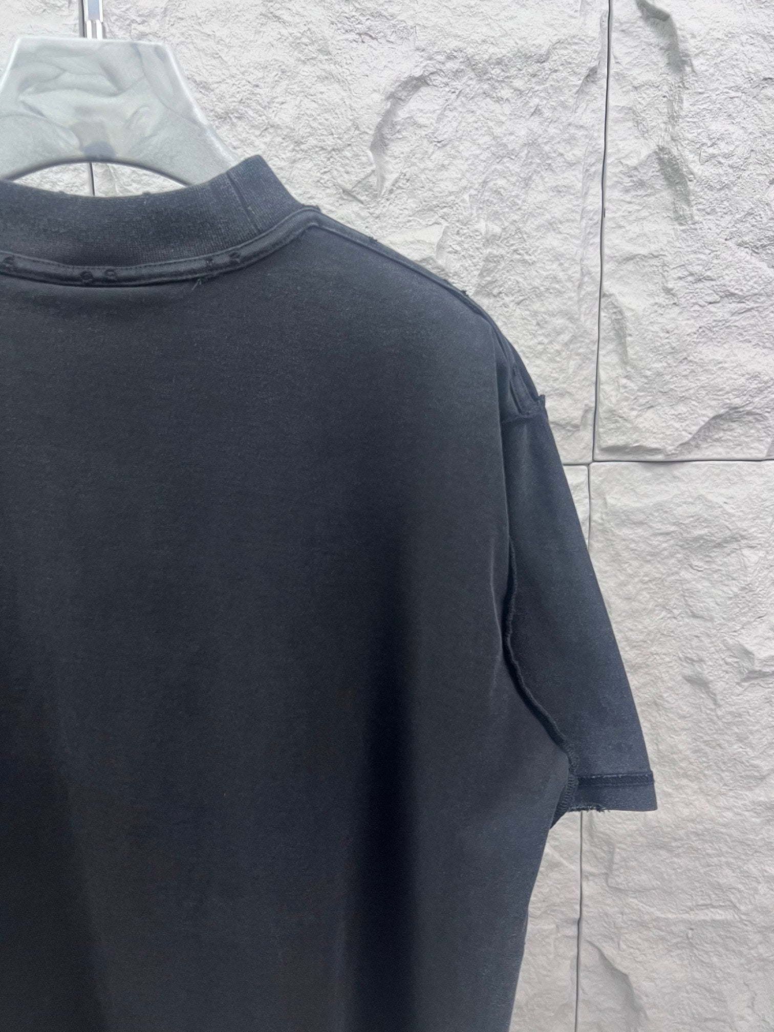 Dark T-shirt back and sleeve close-up with side seam detail