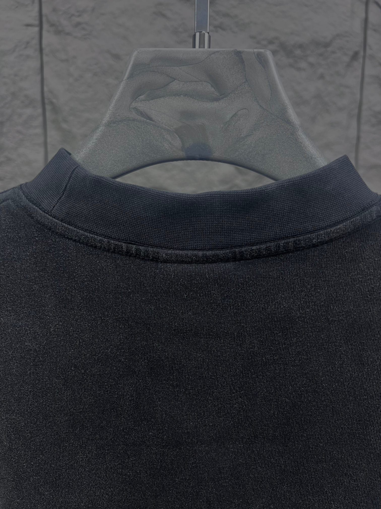 Balenciaga short-sleeve T-shirt, close-up of dark crew collar with visible stitching