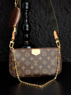 Monogram crossbody bag with gold chain, brown front flap and green strap