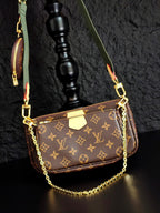 Monogram crossbody bag with gold chain and brown front flap, green strap
